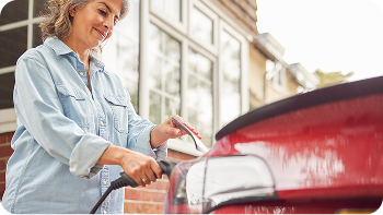 image of a middle aged woman charging her electric car